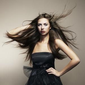 Portrait of young dancing woman with long flowing hair. Fashion